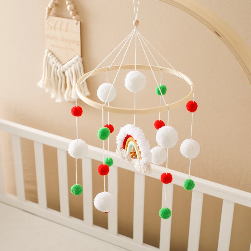Mobile pour bébé avec pompons colorés et éléments arc-en-ciel suspendus, parfait pour éveiller et décorer le berceau.