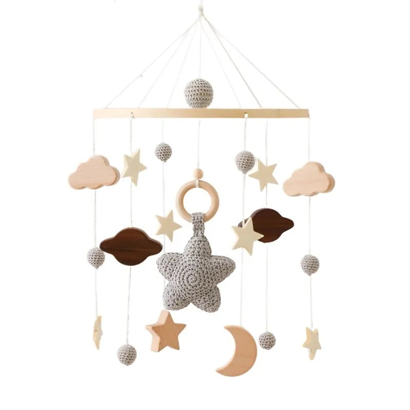Mobile bébé suspendu en bois avec formes d'étoiles et lunes pour stimuler l'éveil des tout-petits, sur fond neutre.
